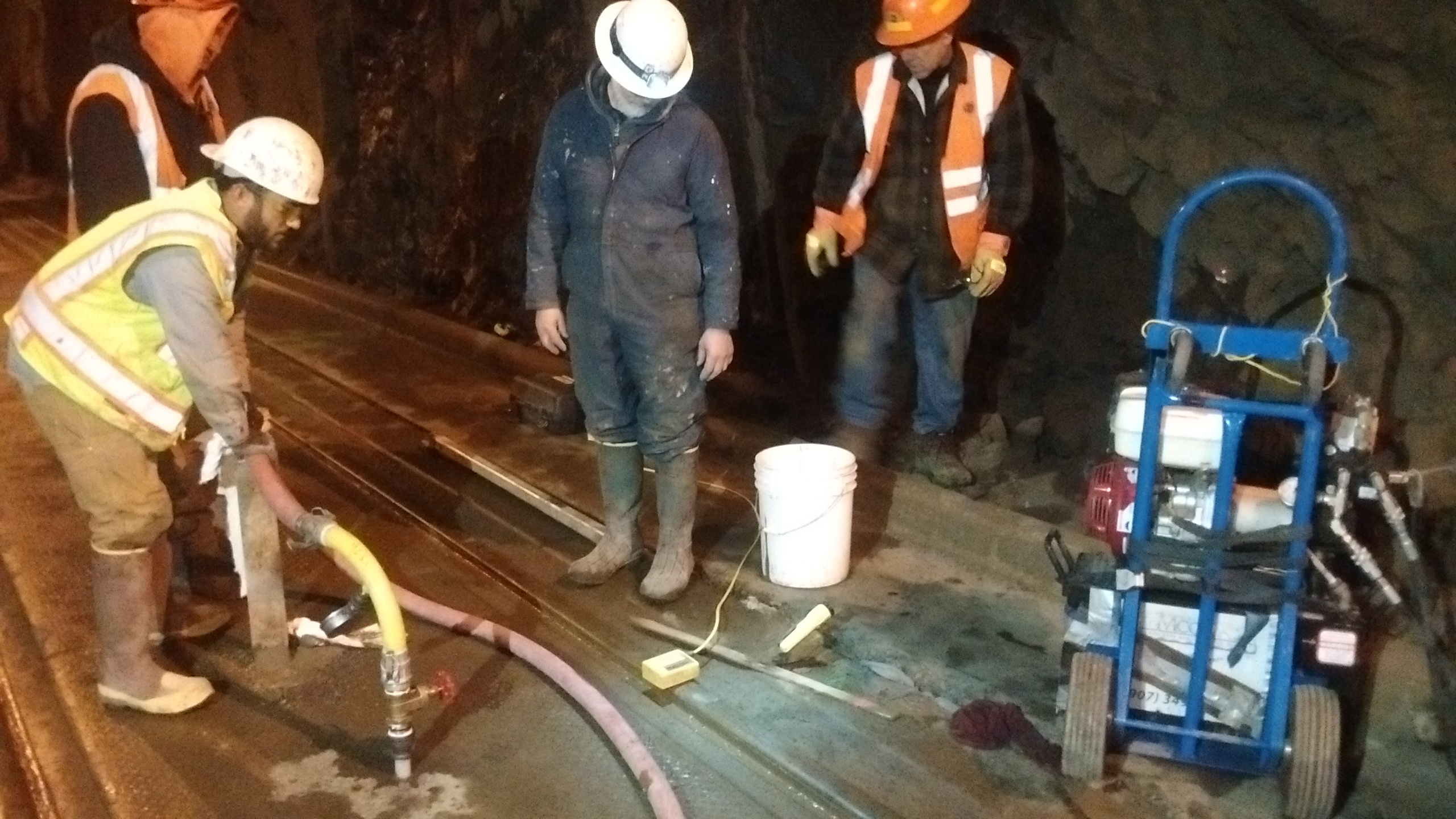 Whittier Tunnel-Lifting and leveling precast panels which RR rails are mounted to, at night.  Grout was mixed in 6 cu ft mixer and injected with single piston pump through custom made, 1" ports in panels.